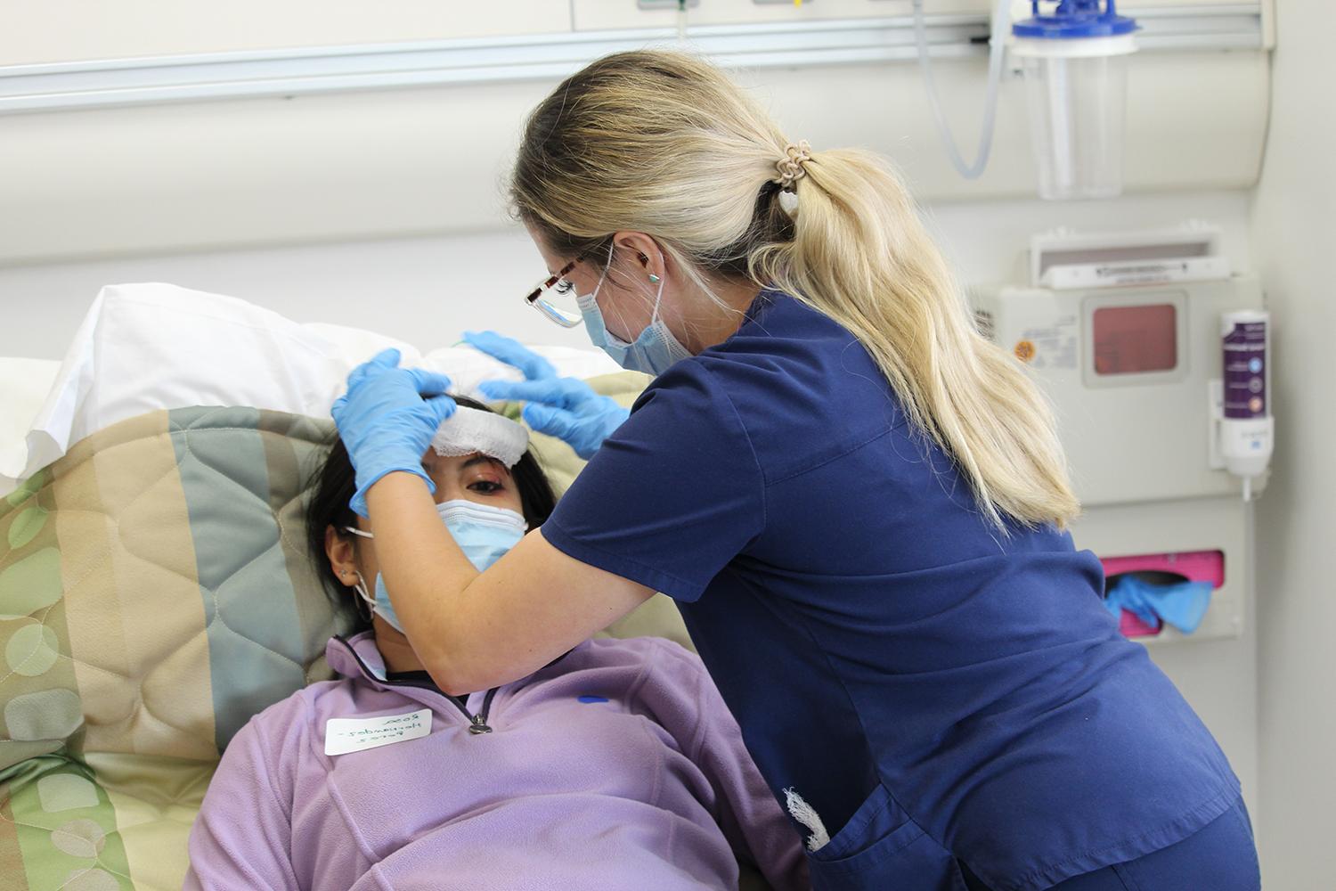 nursing student works on a patient with a mock injury