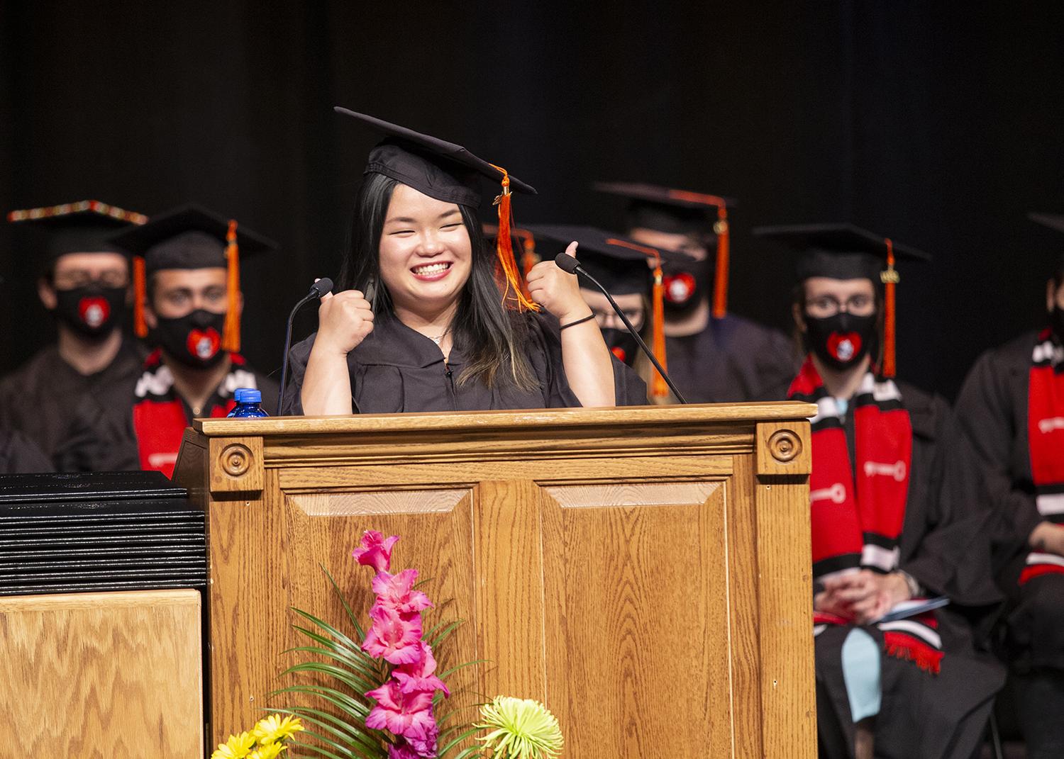 graduate speaker Adele gives two thumbs up on stage