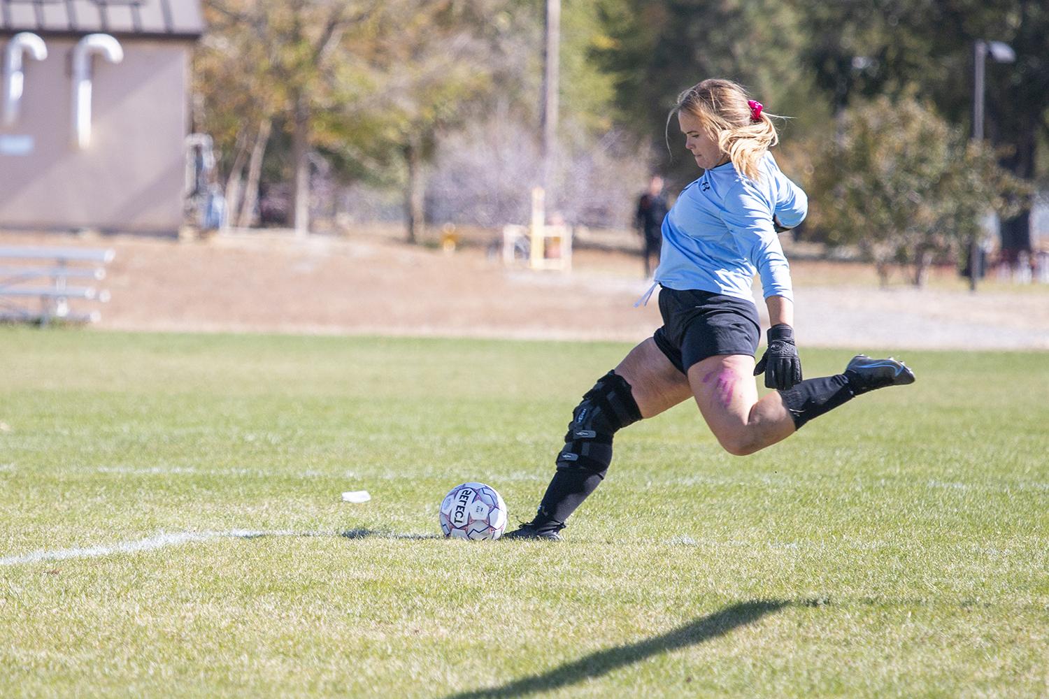 CWC's women's goalie kicks the soccer ball